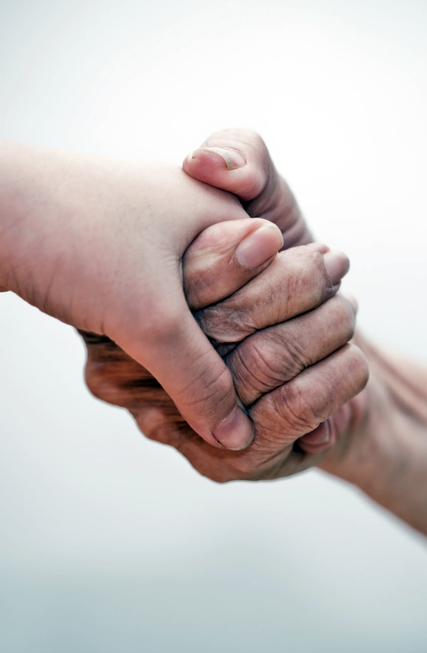 Eine junge und eine ältere Hand halten sich fest